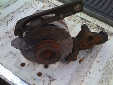 1984 Ford F-250 - This is a close-up of a rusty alternator, likely removed from a vehicle for repair or replacement.