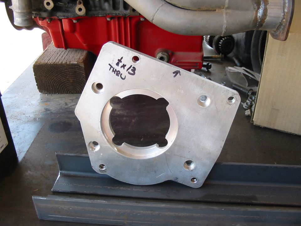 Metal adapter plate with handwritten text '1/4 x 13 THRU' and an arrow