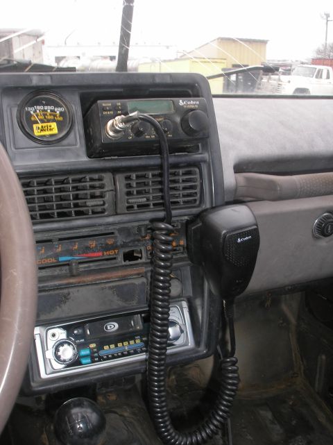 1987 Suzuki Samurai - The interior of a 1987 Suzuki Samurai shows a CB radio, aftermarket stereo, and a gauge on the dashboard.