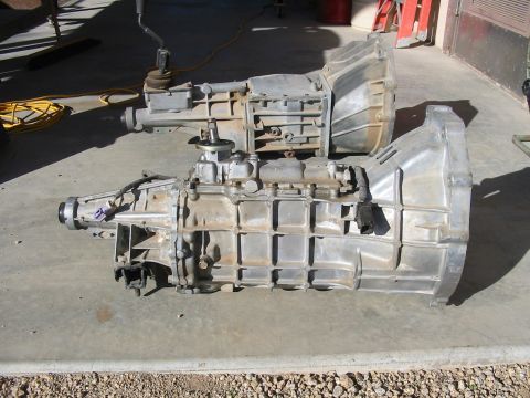1993 Ford Taurus - Two car transmissions are displayed on a concrete floor, possibly for sale or repair.