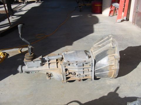 1993 Ford Taurus - A manual transmission is shown resting on a concrete surface, with a yellow cord nearby.