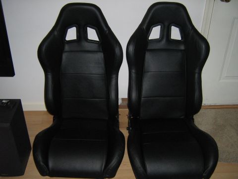 1990 Ford Bronco - A pair of black racing seats are shown from the front, with a subwoofer to the left.