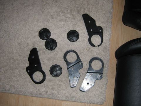 1990 Ford Bronco - Various vehicle parts, including knobs and metal brackets, are displayed on a carpet.