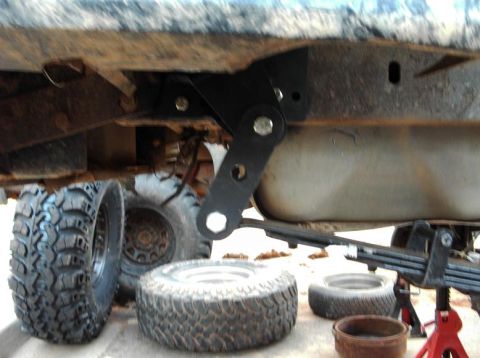 1990 Ford Bronco - Close-up of suspension components and tires, suggesting aftermarket modifications or repairs.