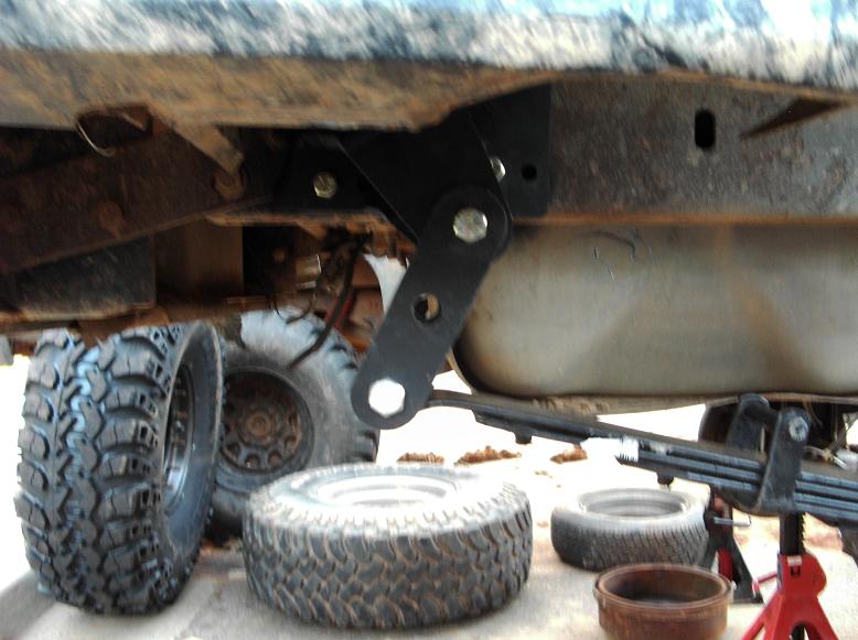 Undercarriage suspension linkage and leaf springs with tires nearby