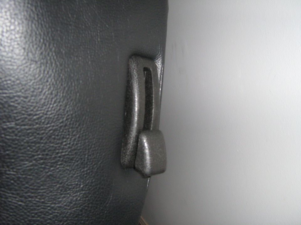Close-up of a black interior door latch mechanism on a textured surface