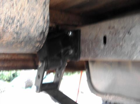 1990 Ford Bronco - A close-up view of a vehicle's undercarriage reveals suspension parts and a tire.