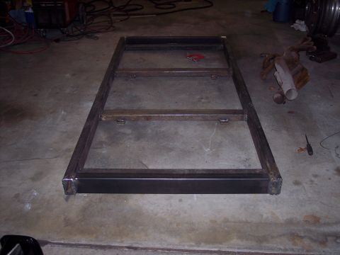 1981 Kenworth W900A - A fabricated metal frame sits on a workshop floor, surrounded by tools and materials.