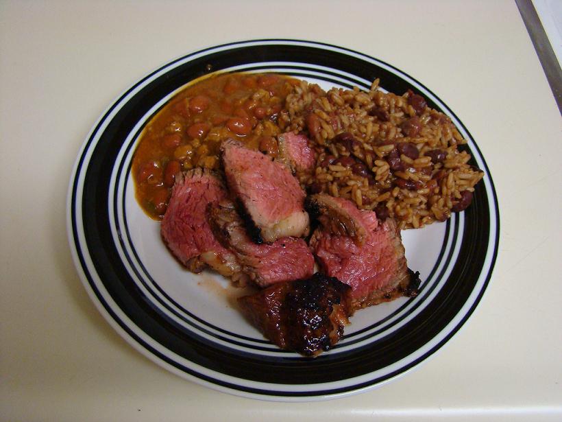 Plate of sliced roast beef with rice and beans