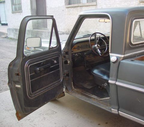 1969 Ford Fairlane - Interior view of a 1969 Ford pickup truck, driver's door ajar, revealing the dashboard and seat.