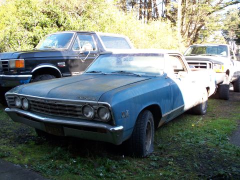 1990 Ford Bronco - A blue 1967 Chevrolet El Camino is parked in front of two Ford trucks.