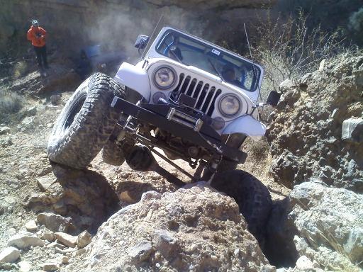 White Jeep climbing rocky terrain