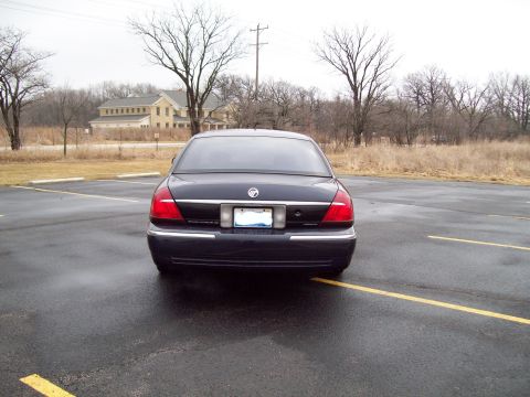1999 Mercury Grand Marquis - Rear view of a dark sedan with chrome accents and distinctive taillights.