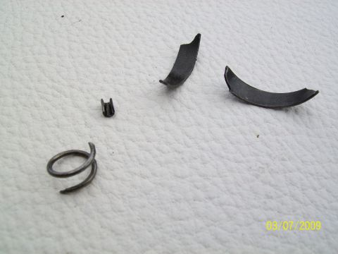 1972 Ford Ranchero - Several small, damaged metal components are scattered on a white, textured background. The image has a date watermark.