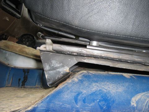 1990 Ford Bronco - Seat mounting hardware and floor area detail within a vehicle's interior.
