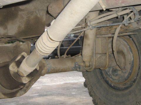 1990 Ford Bronco - Close-up of the rear axle and suspension system of a vehicle, showing various mechanical components.