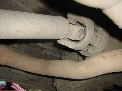 1990 Ford Bronco - Underside view of a vehicle's driveshaft and exhaust system, showing mechanical components.