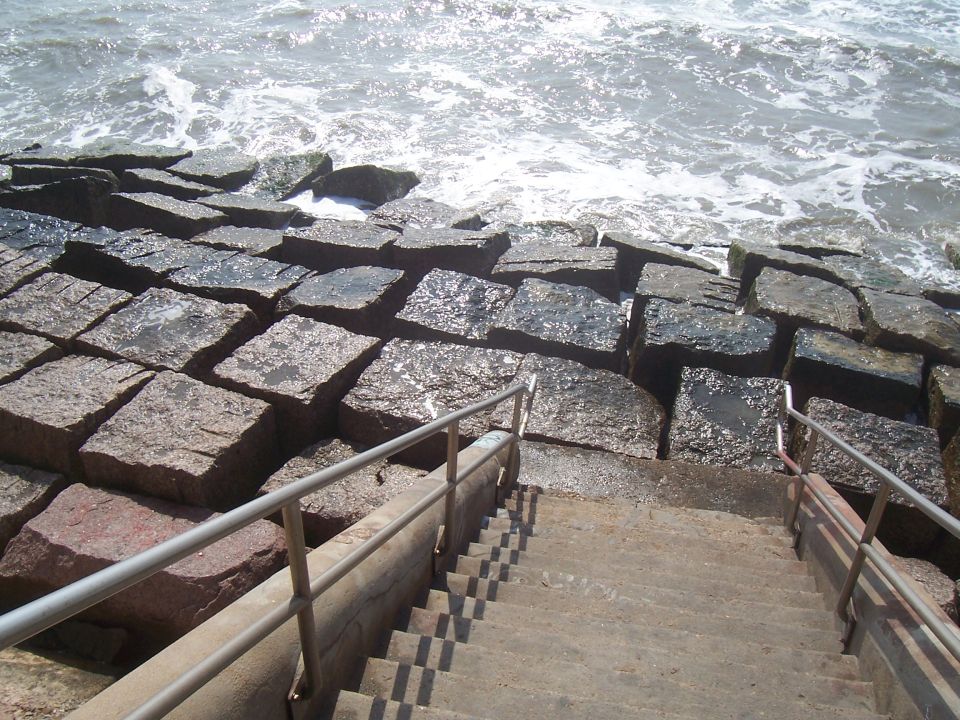 Stone jetty with concrete stairs leading down to the ocean