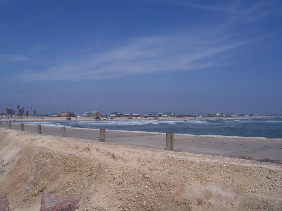 Beach scene with buildings and cars on the sand