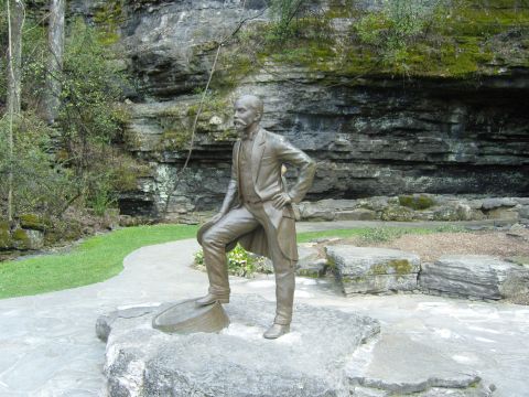 2007 Ford Mustang - A statue of a man in formal attire is positioned outdoors near a rocky cliff face.