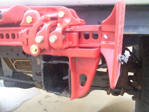 1995 Ford Bronco - Long bolt/nut/washers run through bottom of the jack and into a hole in the side of the frame rail.