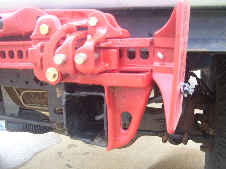 Long bolt/nut/washers run through bottom of the jack and into a hole in the side of the frame rail.