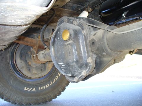 1978 Ford Bronco - This photo shows the rear axle differential and suspension components of a vehicle, with a tire visible.