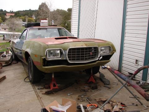 1973 Ford Ranchero - A 1973 Ford Ranchero is shown on jack stands, appearing to be undergoing repairs or restoration.