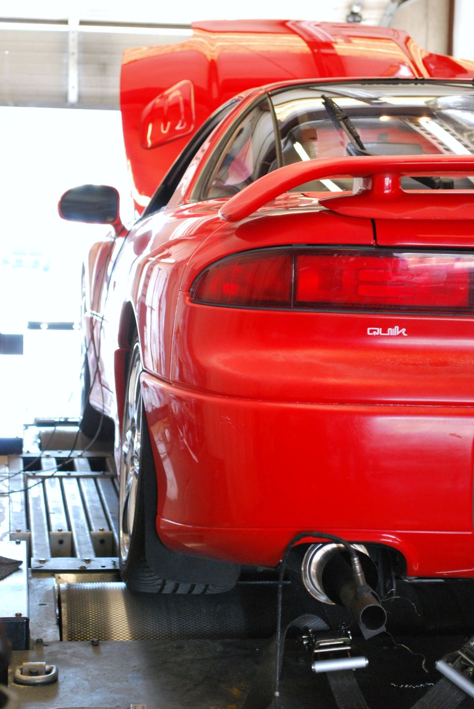 Red 1991 Mitsubishi 3000GT rear on dynamometer rollers, hood open