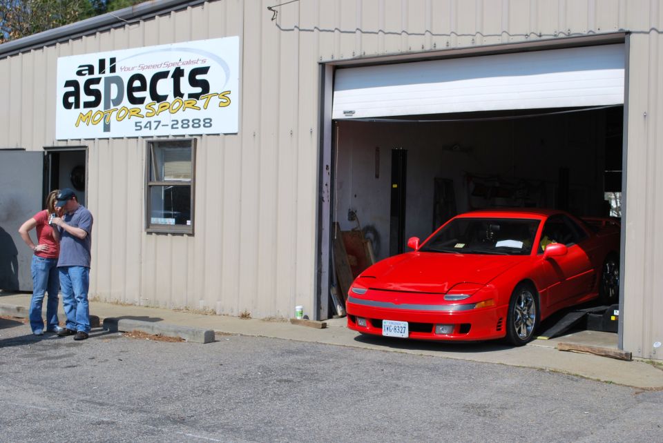 Red 1991 Mitsubishi 3000GT parked in a garage bay