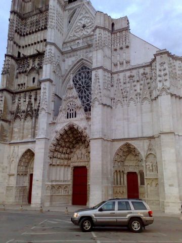 1991 Ford LTD Crown Victoria - Photograph of a cathedral facade and SUV, not a technical document.