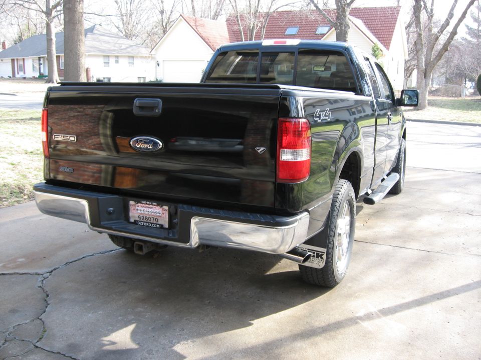Rear of a black Ford F-150 extended-cab 4x4 pickup in a driveway