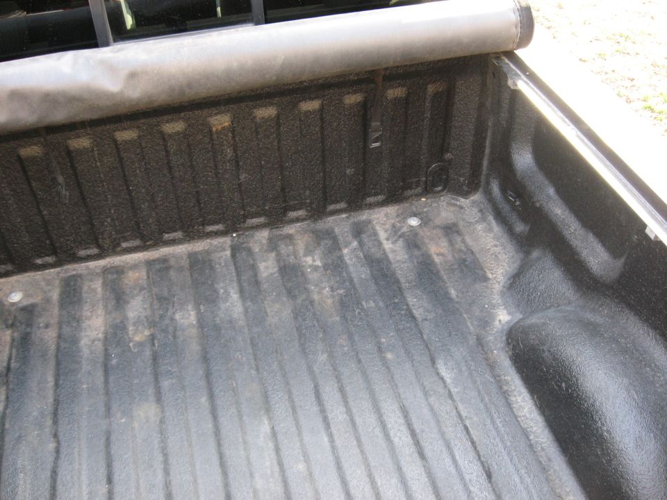 Empty pickup truck bed with black spray-in bedliner
