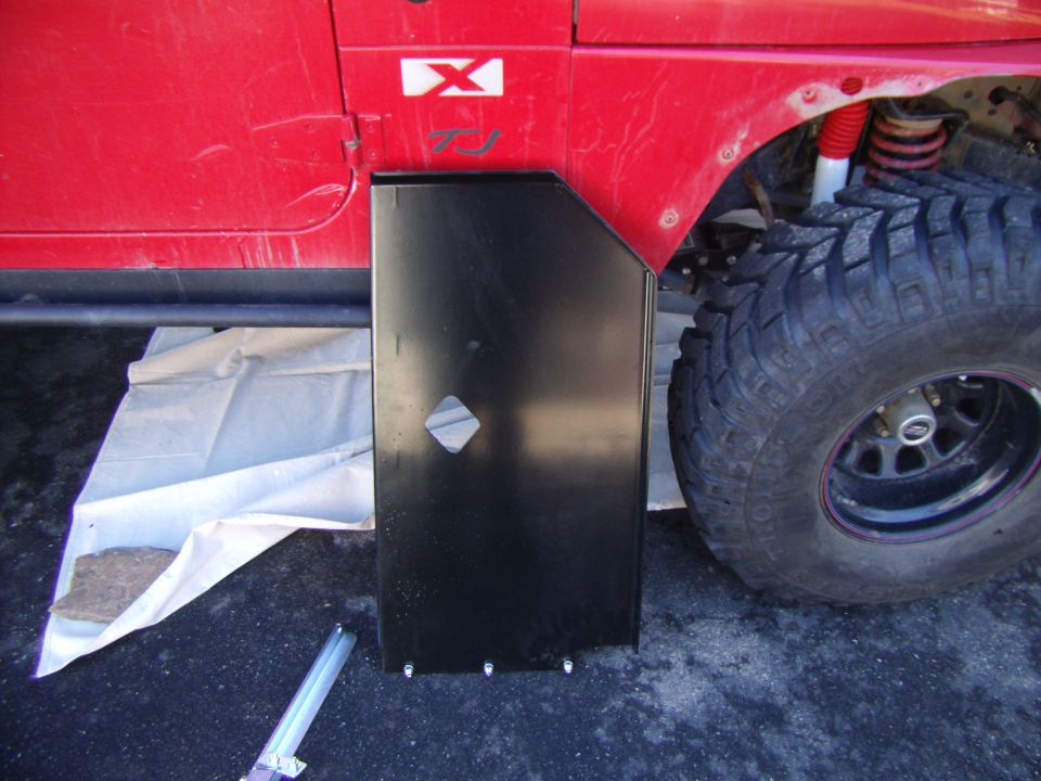 Red Jeep Wrangler with black metal fender flare and large off-road tire