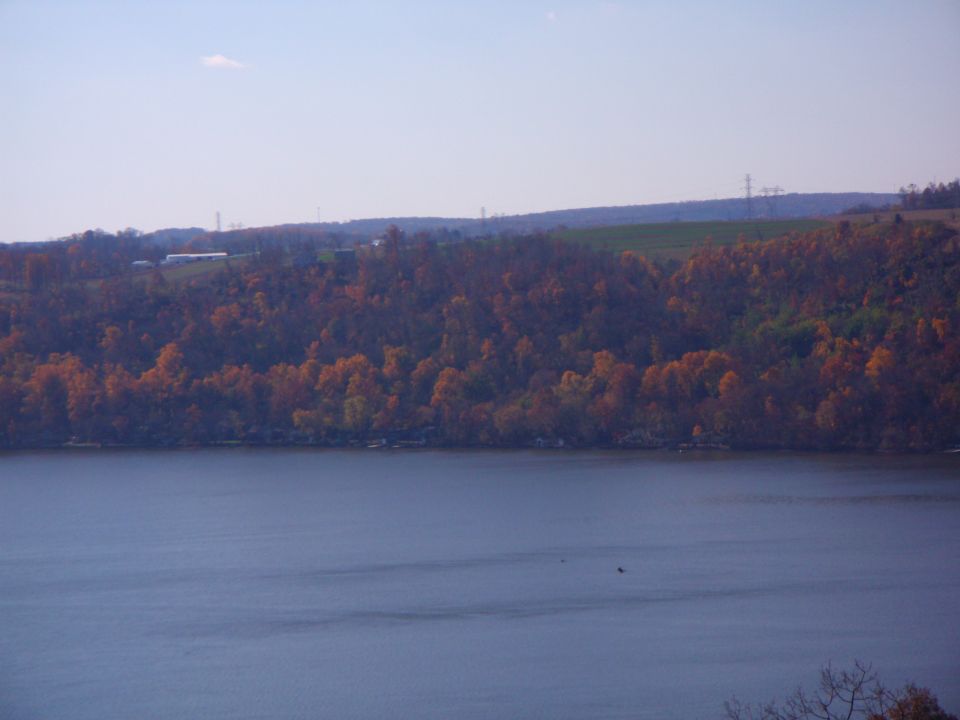 A lake with autumn foliage on the hills in the background.