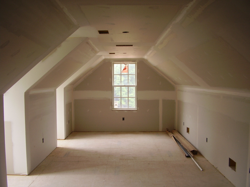Unfinished room with drywall, sloped ceiling, and a window.