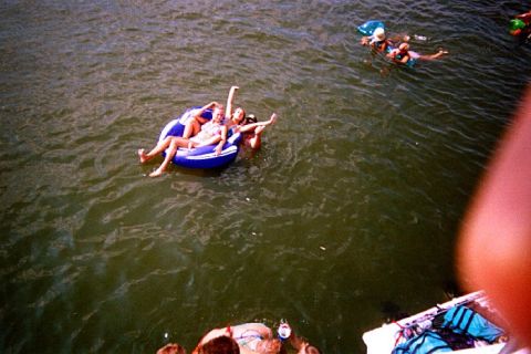 1982 Ford Bronco - Several individuals enjoy a sunny day floating on inflatable tubes in the water.