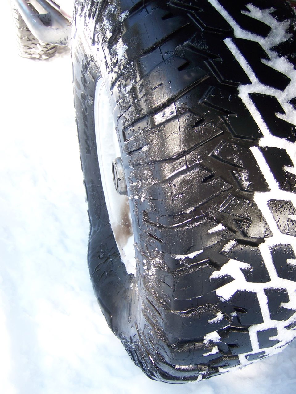Close-up photo of an off-road tire tread in snow