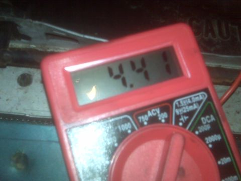 1995 Ford Bronco - A red digital multimeter displays "4.41" on its screen, likely measuring voltage or current. The multimeter is positioned in front of a dar…