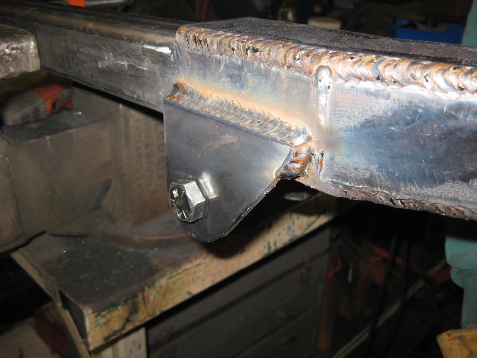 Welded metal bracket with hex bolt on steel beam.
