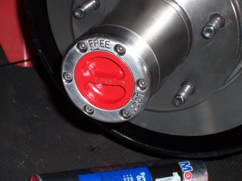 1978 Ford Bronco - A close-up view of a manual locking hub on a vehicle's wheel, featuring red accents and the text "FREE" and "LOCK" around the central "FORD…