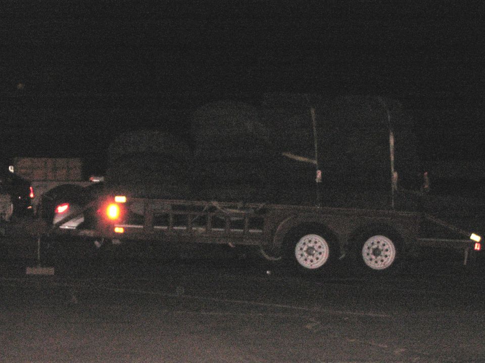Trailer with round bales at night
