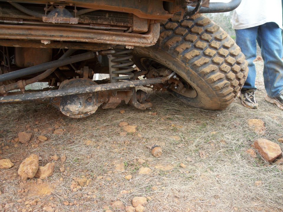Undercarriage of a lifted 4x4 with large tire, suspension, and differential.