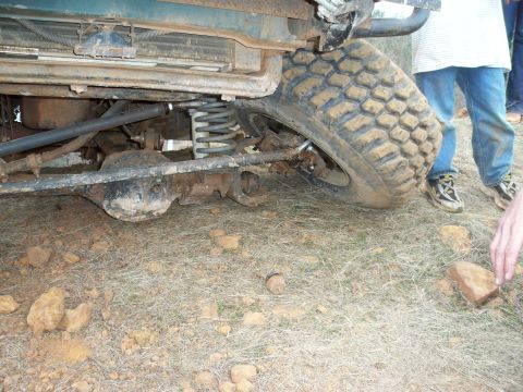 1996 Ford Bronco - The undercarriage and tire of a vehicle are shown in detail, with people standing in the background.