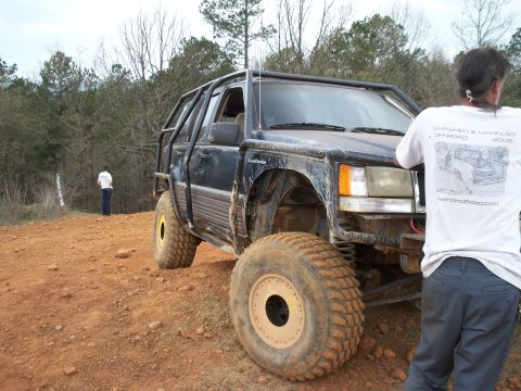 1996 Ford Bronco - A modified Jeep Grand Cherokee sits on a dirt trail, equipped for off-road adventures.