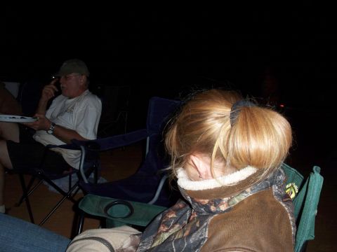 1996 Ford Bronco - People gathered outdoors at night, seated in camping chairs.
