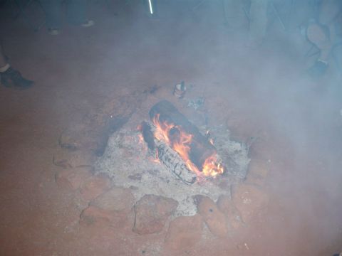 1996 Ford Bronco - A campfire burns brightly amidst smoke, with people visible in the background.