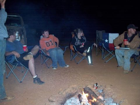 1996 Ford Bronco - Campfire gathering at night with friends, a vehicle is parked nearby.