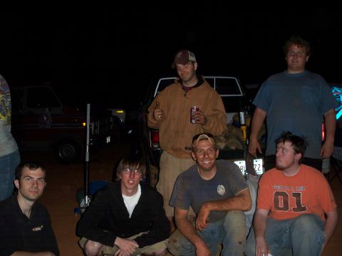 1996 Ford Bronco - Several men pose for a photo at night with two pickup trucks visible behind them.