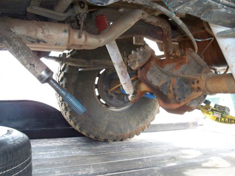1996 Ford Bronco - Close-up view of the undercarriage of a vehicle, revealing its rear axle and suspension system.